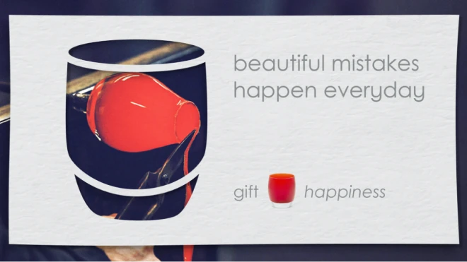 A red glass piece being made in glassblowing process within the shape of a votive, with the text "beautiful mistakes happen everyday". Below, the words "gift" and "happiness" are shown.