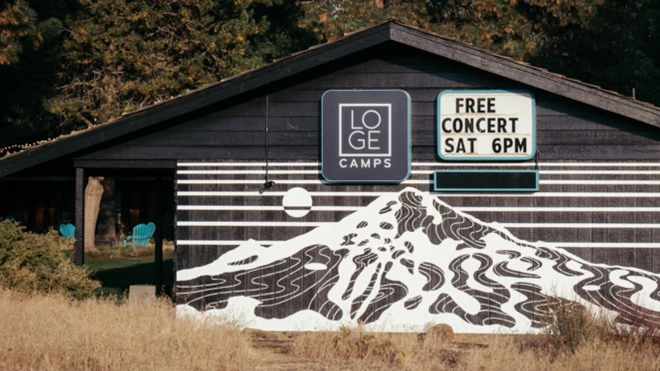 LOGE Camps building with mountain mural and a sign advertising a free concert on Saturday at 6 PM