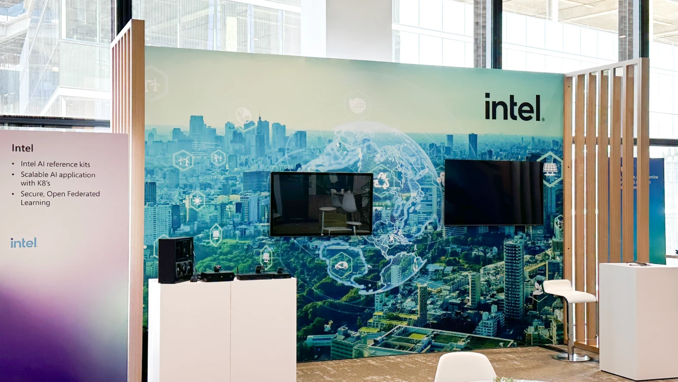 An exhibition booth for Intel displaying a cityscape overlaid with digital graphics representing technology and global connectivity.